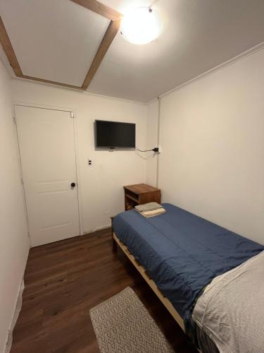 a bedroom with a bed and a tv on the wall at Tu Espacio RE - Casa cerca del Aeropuerto in Santiago