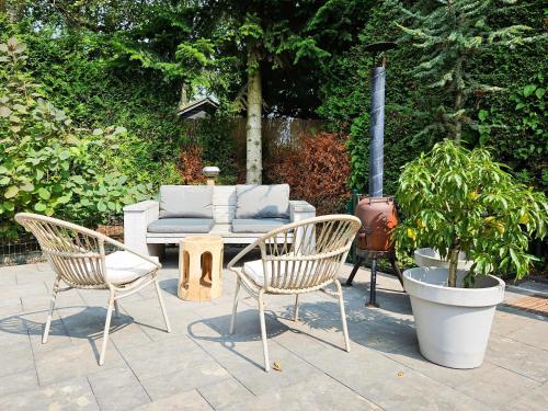 a patio with two chairs and a table with a stove at Chalet Kieftveen with hot tub for four Person in Voorthuizen