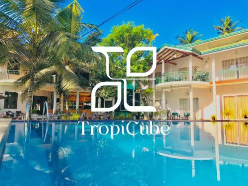a villa with a swimming pool and palm trees at Lake View Resort by TropiCube in Pamunugama