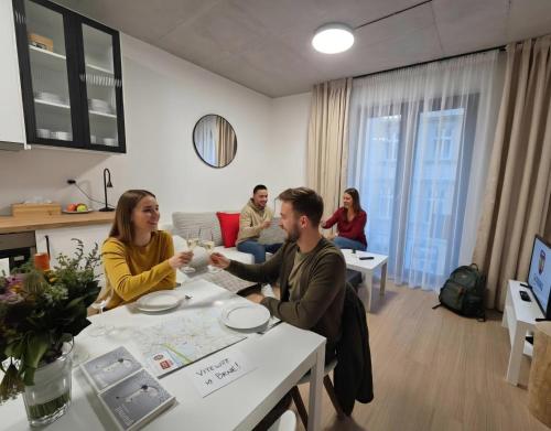 a group of people sitting at a table in a room at Haas Apartments Art with parking, bakery, coffea in Brno