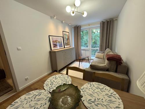 a living room with a table and a couch at Apartament - Mieszkanie, nocleg przy Centrum Zdrowia Dziecka - Warszawa Międzylesie Wawer - Dzięcieliny 15 in Warsaw