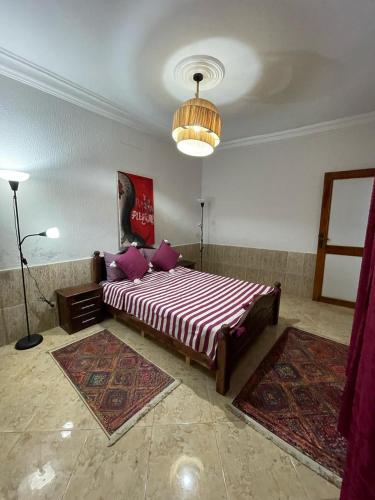 a bedroom with a large bed in a room with rugs at Youness House in Aourir