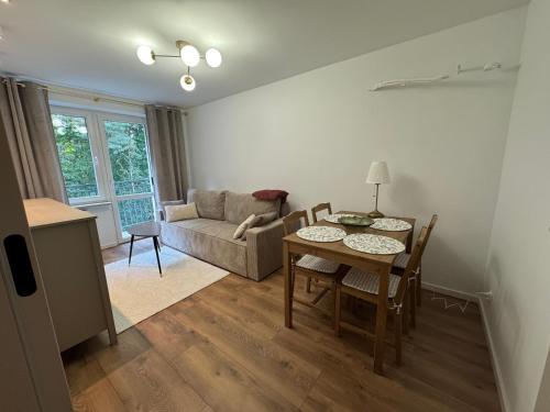 a living room with a table and chairs and a couch at Apartament - Mieszkanie, nocleg przy Centrum Zdrowia Dziecka - Warszawa Międzylesie Wawer - Dzięcieliny 15 in Warsaw