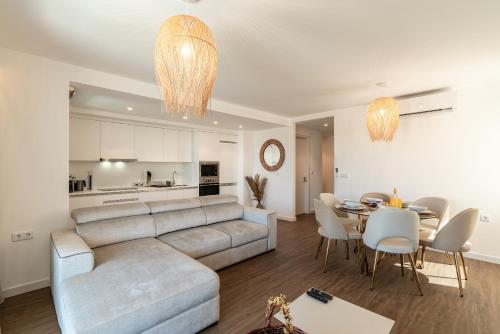 a living room and dining room with a couch and a table at Star Lit Jacuzzi Apartment in Câmara de Lobos