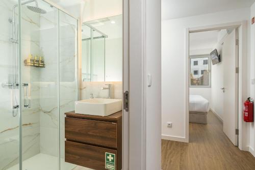 a bathroom with a sink and a glass shower at Star Lit Jacuzzi Apartment in Câmara de Lobos