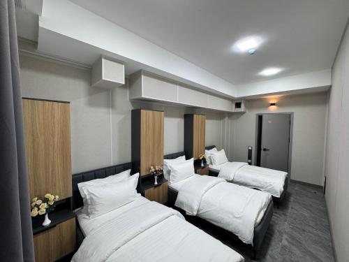 a hotel room with three beds with white sheets at Art City Hostel in Salor Bekati