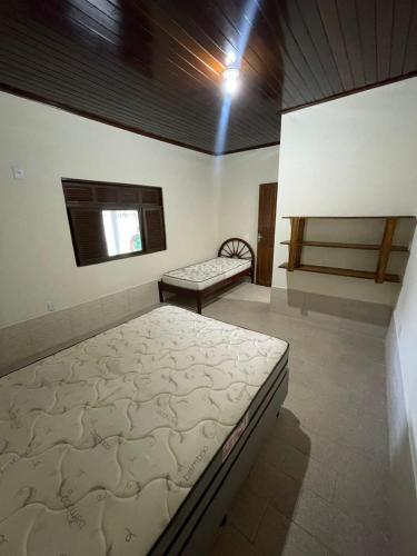 a bedroom with two beds in a room with a window at Recanto dos Goianos 2 - Prado Bahia in Prado