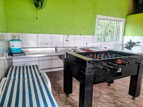 a kitchen with a ping pong table in a kitchen at Chacara Rancho da Cris in Ibiúna