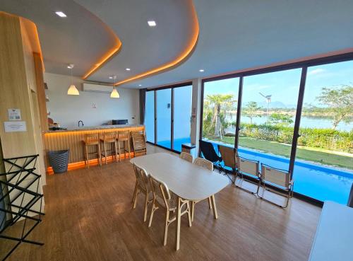 a dining room with a table and chairs and a pool at Sunrise Resort & Cafe - ซันไรส์ รีสอร์ท & คาเฟ่ in Nakhon Phanom
