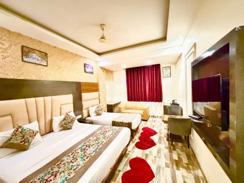 a hotel room with two beds with red hearts on the floor at Smart Plaza Hotel - Free Airport Drop in New Delhi