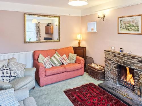 a living room with a couch and a fireplace at Carreg Yr Eos - Cottage in Fishguard