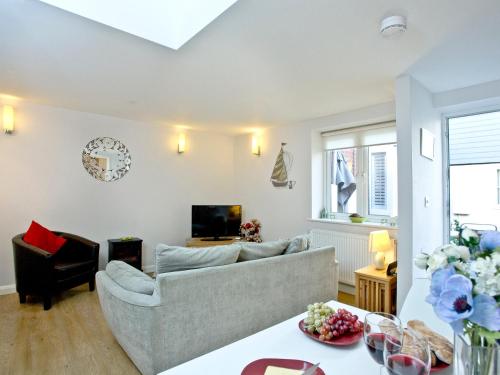 a living room with a couch and a tv at Little Gem in Weymouth