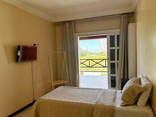a bedroom with a bed and a sliding glass door at Quarto compartilhado 8 leitos Valor por pessoa in Aracaju