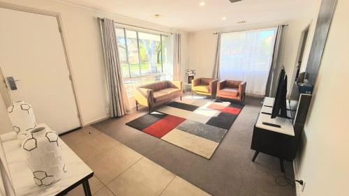 un soggiorno con un divano, sedie e un tavolo di Timeless Tranquility a Belconnen