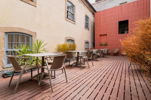 a patio with tables and chairs on a wooden deck at Casa dos Lóios by Shiadu in Porto
