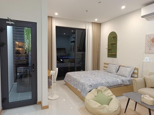 une chambre avec un lit, une chaise et un canapé dans l'établissement Căn studio tại Sentosa Hải Phòng view sông phố cao tầng, à An Khê