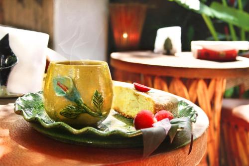 a plate with a coffee cup and a piece of cake at Cabañas Biuzaa in Zipolite