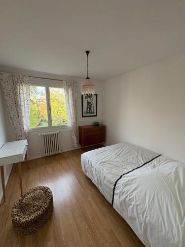 a white bedroom with a bed and a window at Entre Lac, Fleurs et Montagnes in Thonon-les-Bains
