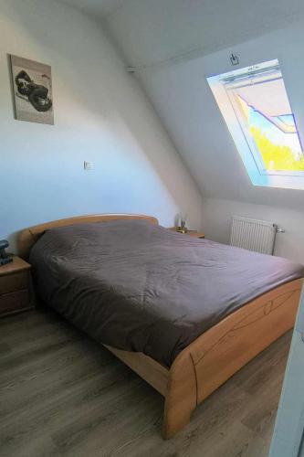 a bedroom with a wooden bed with a window at Het Zonnetje Zonnebeke in Zonnebeke