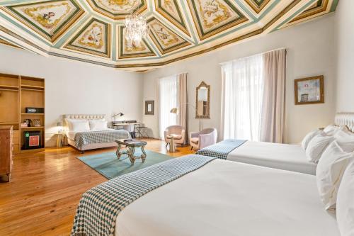 a bedroom with a large bed with a coffered ceiling at Casa dos Lóios by Shiadu in Porto