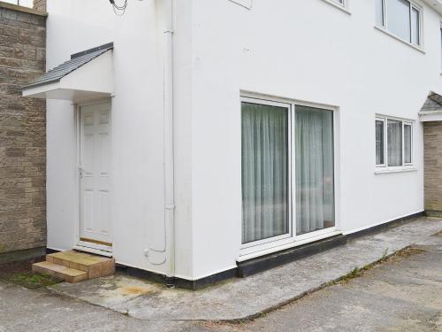 a white house with a door and windows at Glan-Mor in Pwllheli