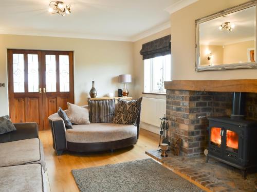 a living room with a couch and a fireplace at Chapel House in Dearham