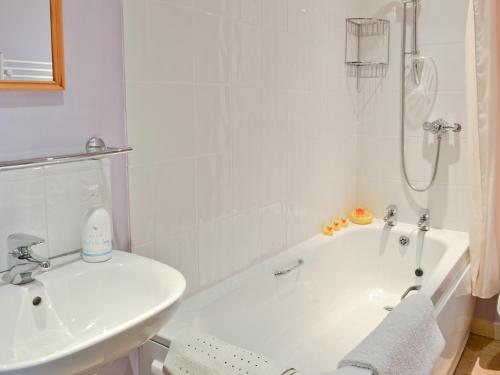 a white bathroom with a sink and a bath tub at Dragonfly Two in North Newton