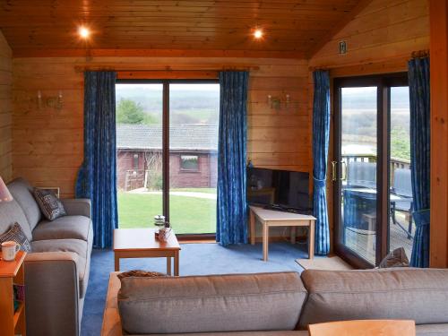 ein Wohnzimmer mit Couch und großem Fenster in der Unterkunft Lodge 59 in Woolfardisworthy