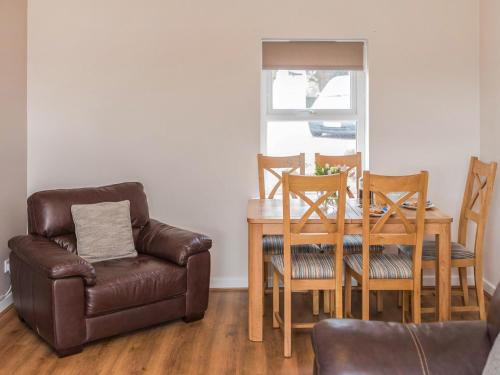 a living room with a table and a chair and a couch at Gatekeepers Cottage Uk6728 in Lydstep