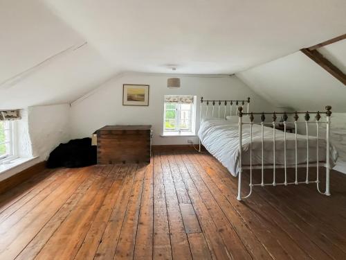 a bedroom with a bed and a wooden floor at Camelot in High Ham