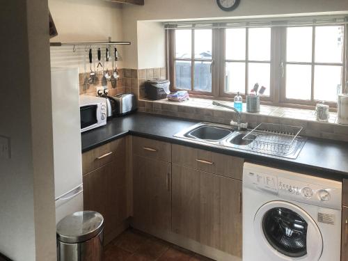 a kitchen with a sink and a washing machine at Dragonfly 3 in North Newton