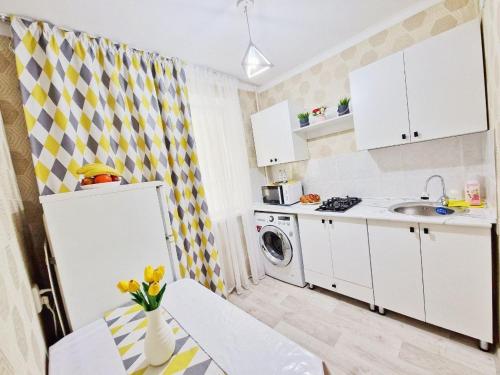 a small kitchen with a sink and a refrigerator at Квартира после ремонта in Taraz