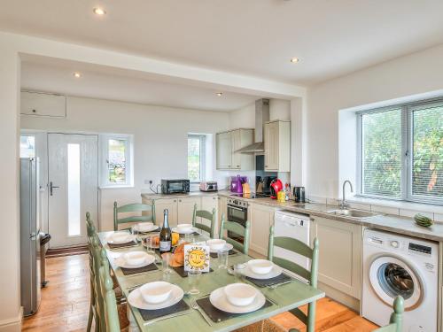 a kitchen with a table with chairs and a sink at Maes Teg in Abererch