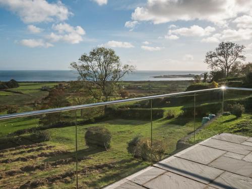 a view of the ocean from the balcony of a house at Maes Teg in Abererch