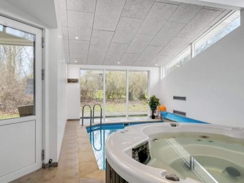 a large bathroom with a tub and a swimming pool at 8 person holiday home in Græsted-By Traum in Udsholt Sand