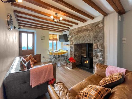 un salon avec un canapé et une cheminée dans l'établissement Ty Capel Cottage, à Betws-y-coed