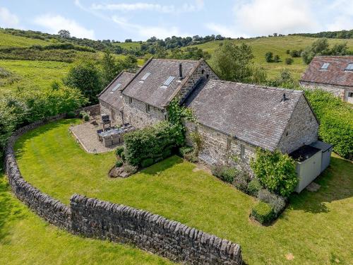 an aerial view of an old stone house in a field at Waterside Barn in Bradbourne