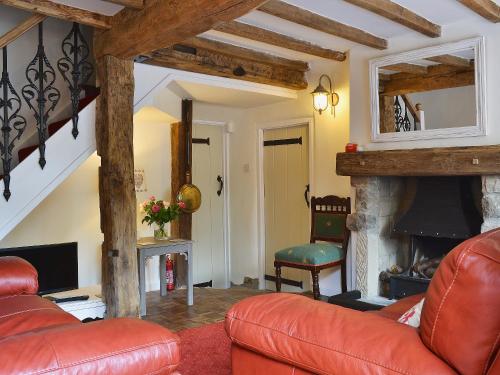a living room with a red couch and a fireplace at Post Office Cottage in Highpeak Junction