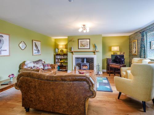 a living room with two couches and a fireplace at The Stables in Cheddar