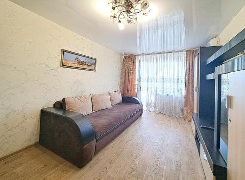 a living room with a couch in front of a window at Апартаменты Marin в самом центре in Kharkiv