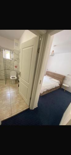 a bedroom with a bed and a bathroom with a toilet at Anacor in Dubova