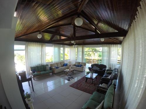 
a living room filled with furniture and a large window at Recanto do Teimoso in Ubatuba
