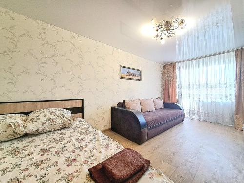 a bedroom with a bed and a chair in it at Апартаменты Marin в самом центре in Kharkiv
