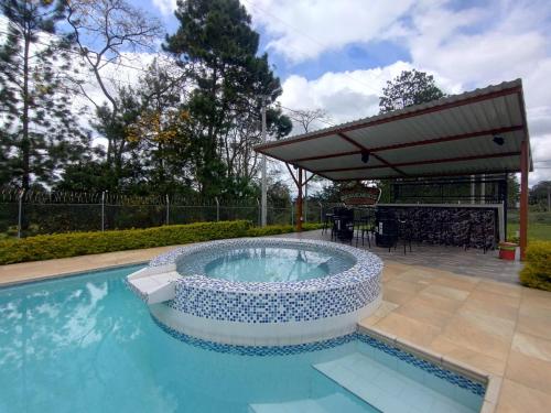 una piscina con pérgola y una piscina en Parcela el privilegio, en Totoró