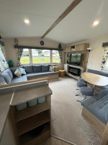 una sala de estar con un sofá y una mesa en L20 at Seven Bays Park, en St Merryn