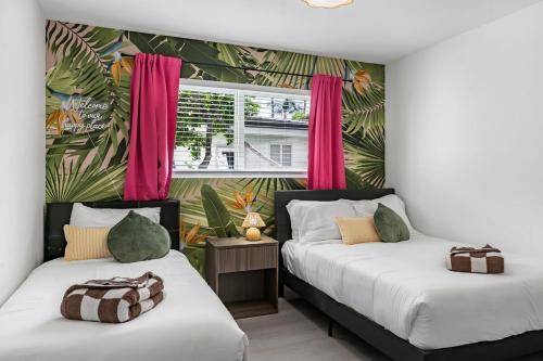 - 2 lits dans une chambre avec des rideaux roses dans l'établissement Casa Blanca Lighthouse Point with 4 BR with Pool, à Lighthouse Point