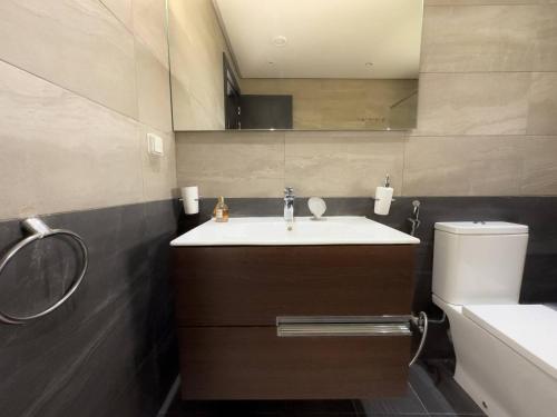 Un baño con lavabo, inodoro y espejo. en Ocean Escape Luxury Duplex With Sea View & Pool, en Tamraght Ouzdar