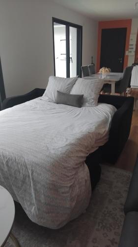 a large bed in a bedroom with a table and chairs at Maison de campagne in Périssac