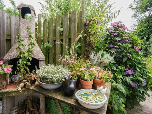 a garden with pots of flowers and a fence at Bungalow in Landgraaf with terrace in Landgraaf