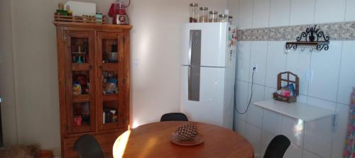 Una cocina con una mesa de madera y un refrigerador. en Quarto Rustico em Alfenas, en Alfenas